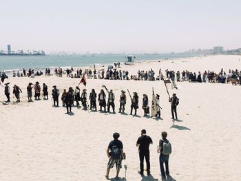 People on beach against clear sky