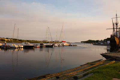 Sailboats in sea at sunset