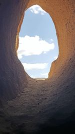 Scenic view of sky seen through hole in tunnel