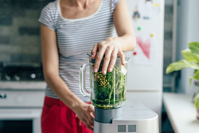 Midsection of woman holding while standing at home