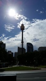 Tower in city against cloudy sky