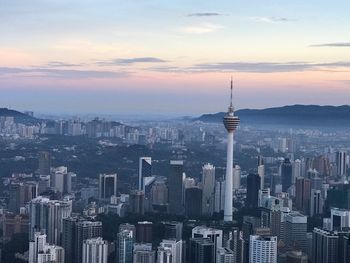 Aerial view of buildings in city at sunset