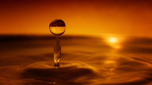 Close-up of rippled water against orange sunset sky