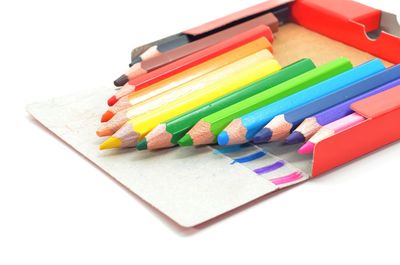 High angle view of colored pencils on white background