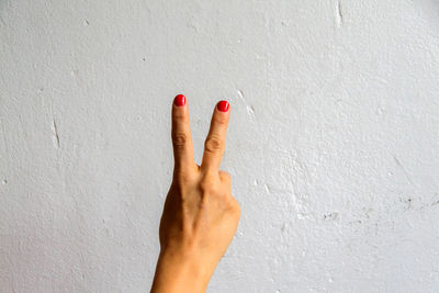 Close-up of woman hand against wall