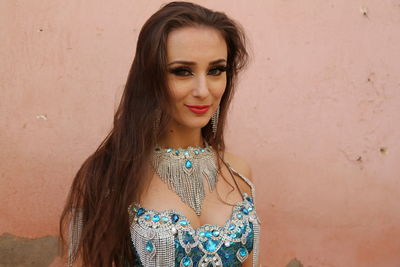 Portrait of beautiful woman standing against wall