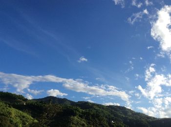 Low angle view of mountain against blue sky