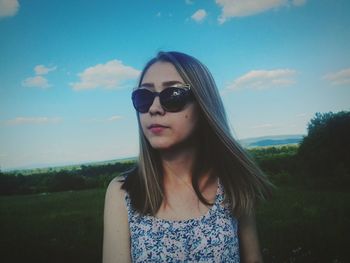 Portrait of young woman in sunglasses against sky