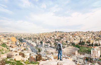 Rear view of man standing on cliff in city