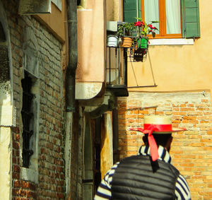 Rear view of man standing by window