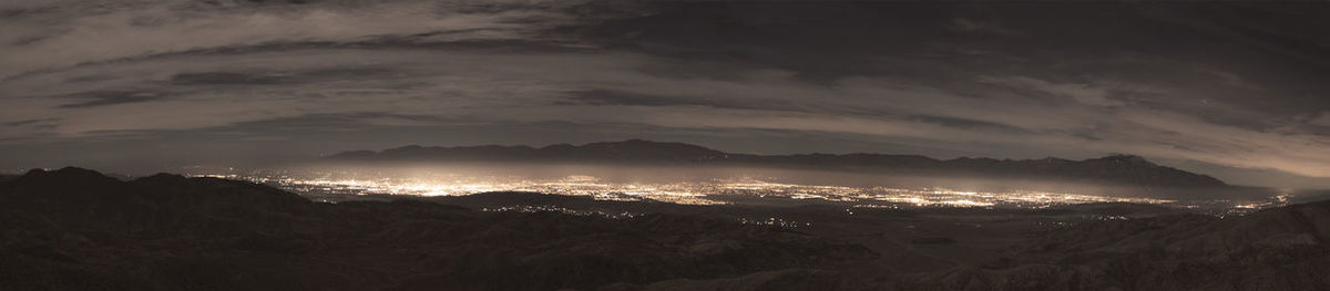 Illuminated city against sky at night