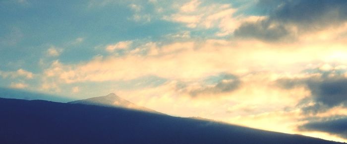 Scenic view of mountains against cloudy sky