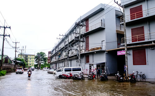 People on street by buildings in city