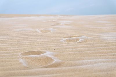 Close-up of sand at beach against sky