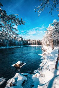 Scenic view of river against sky during winter