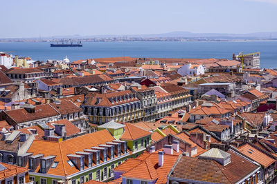 High angle view of townscape by sea against clear sky