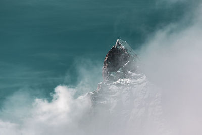 Scenic view of snow covered mountain amidst fog