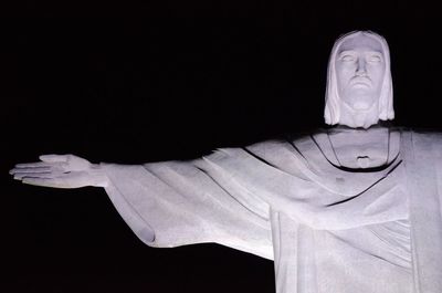 Close-up of jesus christ statue against black background