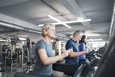 Group of fit seniors on treadmills working out in gym