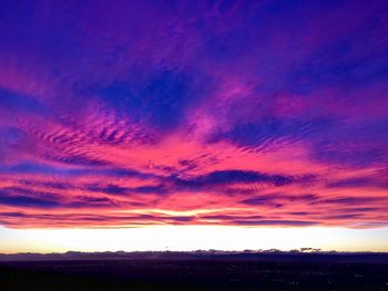Scenic view of dramatic sky over silhouette landscape