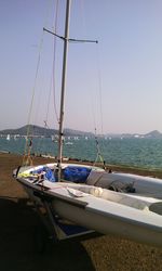 Sailboats moored on sea against clear sky