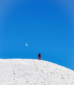 Man on snowcapped mountain against clear blue sky