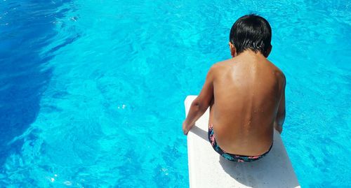 Rear view of child on diving board