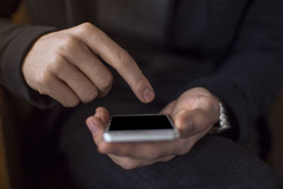 Midsection of man using mobile phone