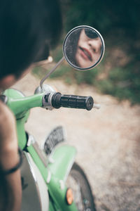 Reflection of woman in side-view mirror