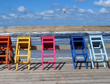 Chairs on beach against sky