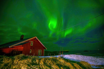 House on field against sky at night