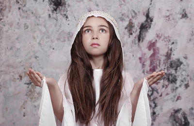 Girl sanding against patterned backdrop