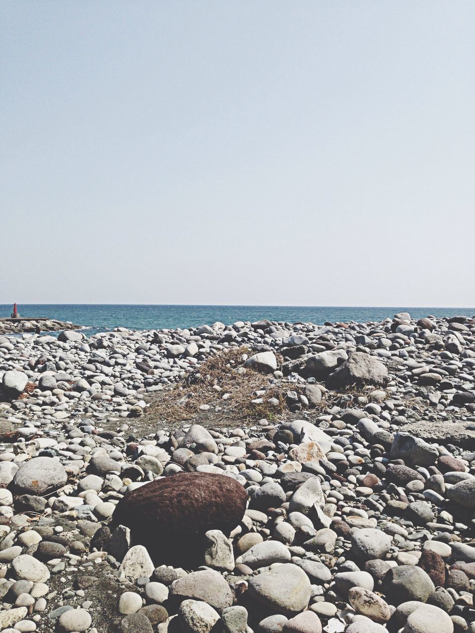 water, sea, beach, rock - object, stone - object, clear sky, pebble, horizon over water, shore, copy space, tranquility, tranquil scene, beauty in nature, nature, scenics, stone, rock, sky, outdoors, day