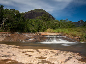 Scenic view of waterfall against sky