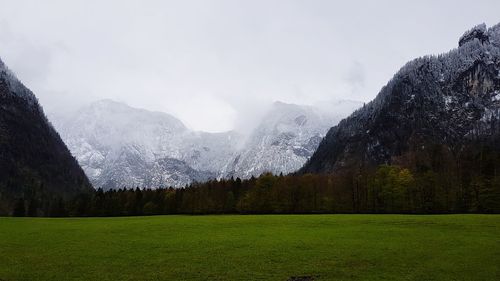 Scenic view of green landscape and mountains against sky