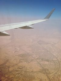 Cropped image of airplane flying over landscape