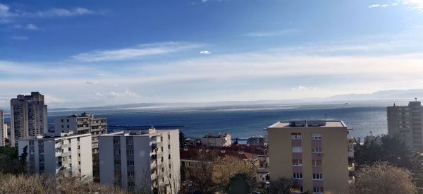 High angle view of buildings by sea against sky