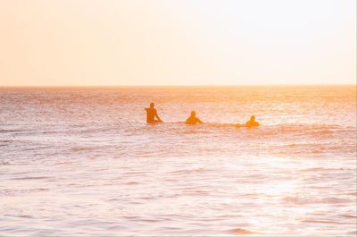 Silhouette of people sitting on beach