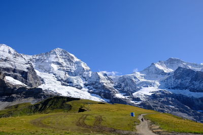 Scenic view of snowcapped mountains against clear blue sky