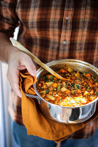 Midsection of man having food in utensil