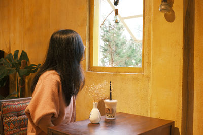 Side view of young woman washing hands at home