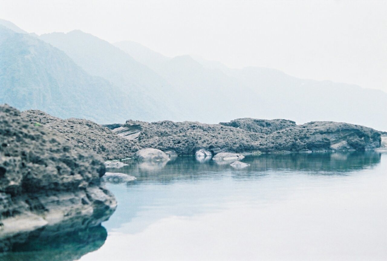 water, mountain, scenics, tranquil scene, beauty in nature, tranquility, nature, mountain range, lake, clear sky, waterfront, sea, rock - object, idyllic, sky, non-urban scene, river, copy space, rock formation, remote