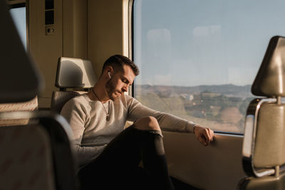 Young male passenger using smartphone in subway