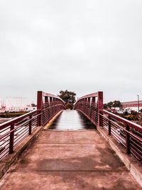 Empty footbridge against clear sky