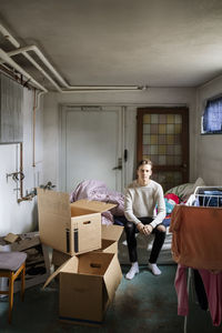 Portrait of man sitting on bed at new home