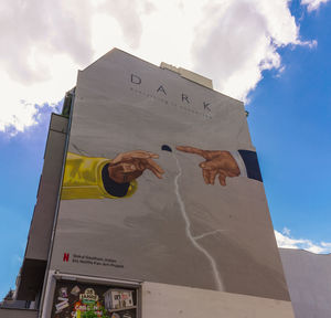 Low angle view of text on building against sky