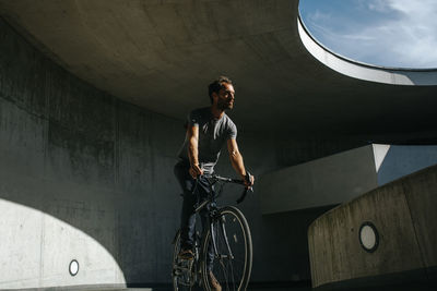 Full length of young man riding bicycle