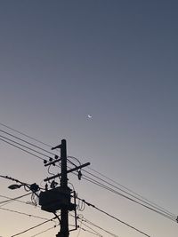 Low angle view of silhouette electricity pylon against sky