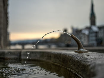 Close-up of water fountain against building