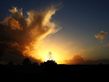 Scenic view of silhouette landscape against dramatic sky during sunset
